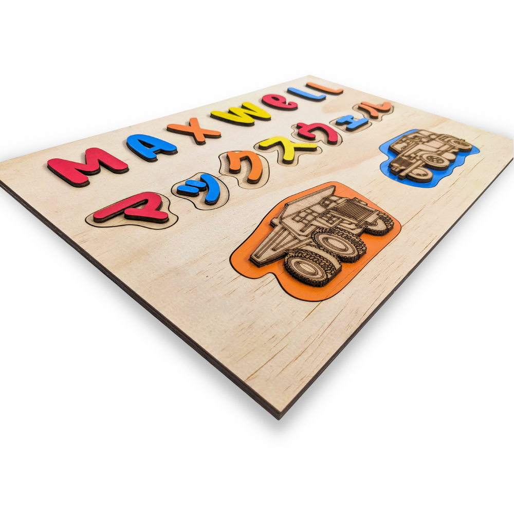 
                  
                    Children's name puzzle with dinosaurs and trucks, for bilingual families - The Charred Plank
                  
                